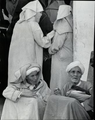 Men talk and, in the background, women wait and watch, hidden behind their veils, only their inquisitive eyes on public show. In, Tunis all is modern (...)