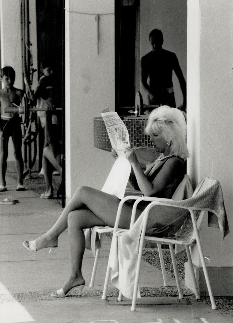 On vacation in Yalta, woman catches up on the news