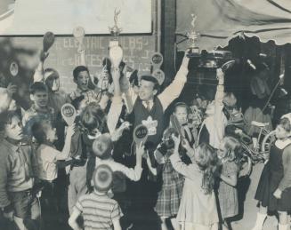 Bo-Lo finals on Oct. 29, Star trophies displayed by Lorne Baurlien, champion of bo-lo, are enthusiastically greeted by young bo-lo fans