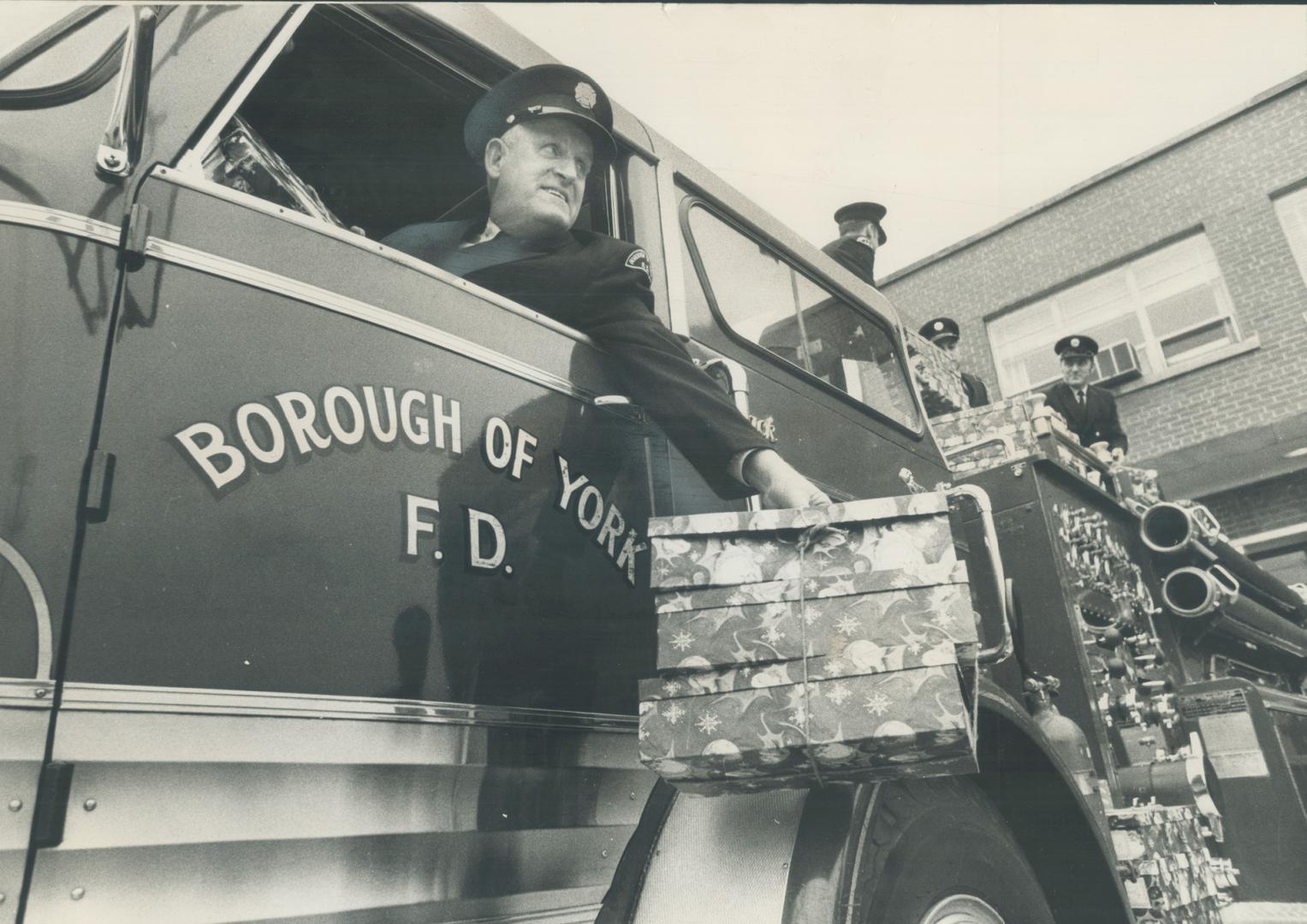 Still doing Santa's chores, as he used to do 38 years ago, Borough of York fireman Sam McKittrick leans out the window of his fire truck with parcels (...)