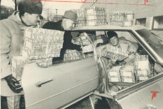 Behind the wheel and ready to take off on his rounds, Ernie Stanton accepts a few last packages from his brother Al, left, and Cecil Martindale. Ernie(...)