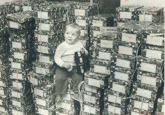 While his mother helps pack gift-boxes at a Dundas St