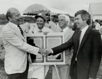 New salmon hatchery opens, Ontario's Minister of Natural Resources Alan Pope (right) presents a plaque to John Brooks (left), The Star's director of c(...)