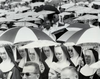 Protected by parasols from the blazing sun at the CNE bandshell Sunday, June 30, 1963, nuns attend special Byzantine Catholic mass. The mass was part (...)