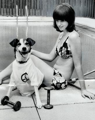 Tippy, a mongrel who has won the last nine times he has been entered in the flyweight class of the dog swimming race held at the CNE, sits with Dianne(...)