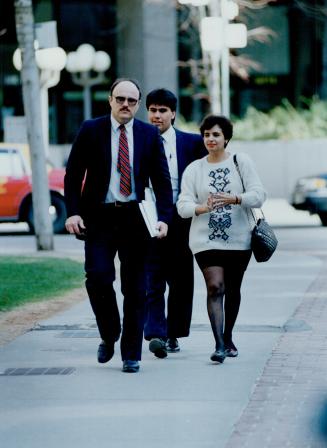 Face charges: Immigration consultant Lucy Da Silva, 24, is escorted to court today by RCMP constables John Dempster, left, and Darcy Fleury