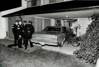 Shattering entrance: Car driven by an estranged husband remains partially in the living room of his wife's house as police check the scene early this morning