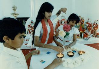 Remembering: In a Richmond Hill service yesterday, Vishwanath Doobay, left, Indira Sharma and Nicole Persad lay a rose garland around candles symbolizing victims of the Air-India crash