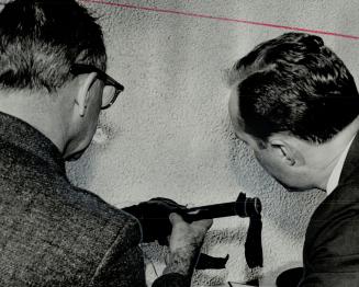 Two more detectives examine this home-made bomb, which was designed to explode when Harvey Torraville stepped on the accelerator of his car while in t(...)
