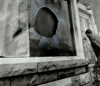 Fire bomb target, A passerby peers into front window at home of Alex George, which was fire bombed this morning