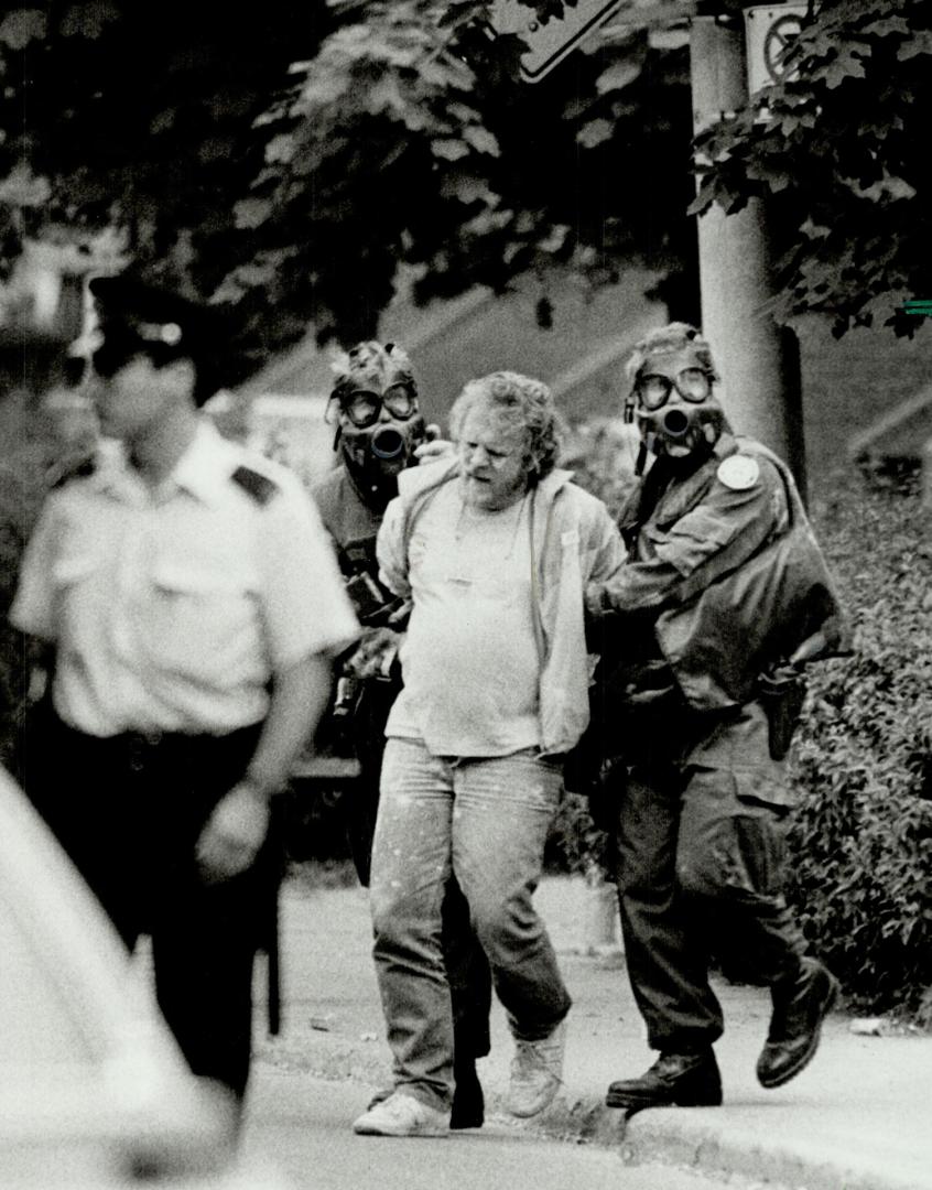 'Powdered suspect': Gas-masked police lead away hostage-taking suspect covered in tear-gas powder