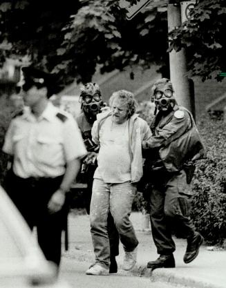 'Powdered suspect': Gas-masked police lead away hostage-taking suspect covered in tear-gas powder