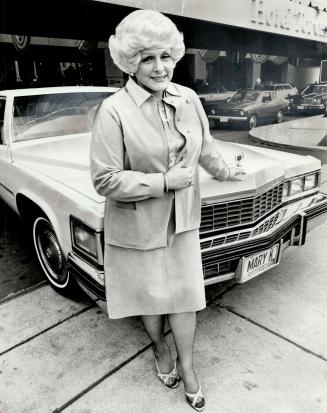 Founder of Mary Kay Cosmetics Mary Kay Ash, in Toronto for opening of firm's new Canadian headquarters in Mississauga, stands in front of one of major(...)