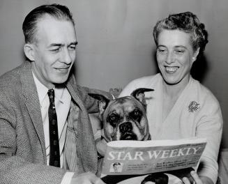 Walter Ball and his wife, Ollie, smile over Walter's Rural Route in The Star Weekly, but their dog, Toby, has more serious thoughts