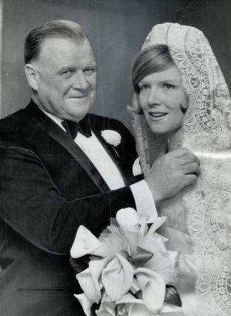 A proud father. Harold Ballard, vice-president of Maple Leaf Gardens, beams as he straightens wedding veil of daughter Mary Elizabeth, prior to her ma(...)