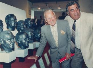 Harold Ballard, owner of hockey's Toronto Maple Leafs and football's Hamilton Tiger-Cats, laughs it up with former Ticat linerman Angelo Mosca as they(...)