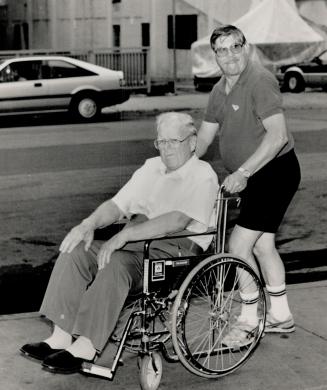 Homeward bound: Maple Leafs trainer Gunner Garrett pushes Harold Ballard, the team's 85-year-old owner, outside the Westbury Hotel where Hal dined with companion, Yolanda