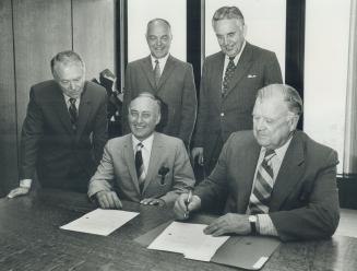Maple Leaf Gardens stock purchase finallised-A happy pair are Stafford Smythe and Harol Ballard as they sign papers to finallise the purchase of Maple(...)