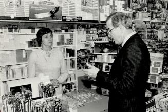 Dallas detective William Dear chats with Janet Vickery, a clerk in a Bolton milk store, who recalled seeing Beckon apparently waiting for someone on the street outside shortly before his death