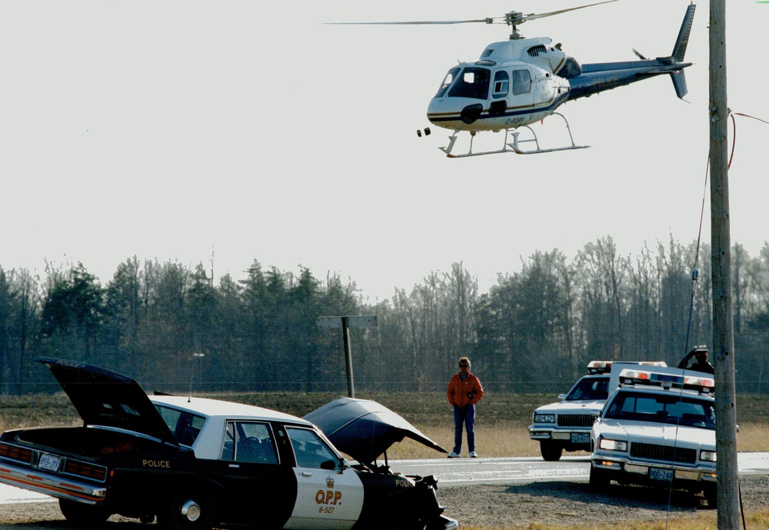 Crime spree: A police helicopter, to, hovers over an OPP cruiser yesterday in Caledon after a hijacked limousine, above left, was forced off the road