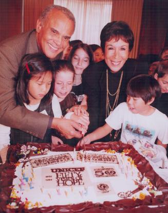 Goodwill Gesture: Harry Belafonte, his wife Julie and children from With-row Public School cut a cake yesterday to celebrate 50 years of UNICEF