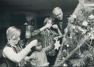 Author Pierre Berton gets help decorating the Christmas tree in his Kleinburg home