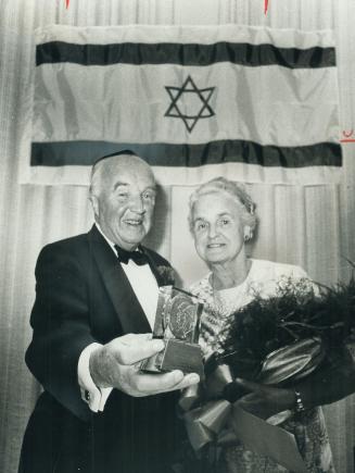 Honor for Dr. Best. Dr. Charles Best. co-discoverer of insulin, and Mrs. Best show the Jerusalem Medal given him last night at Shaarei Shomayim Synago(...)