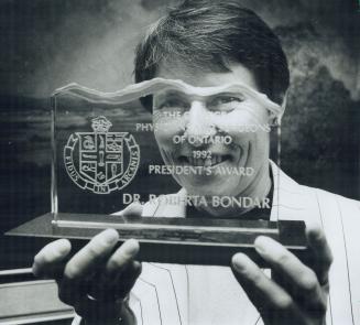 Canada's first female astronaut, Dr. Roberta Bondar, holds up her President's Award from the College of Physicians and Surgeons of Ontario. The award (...)