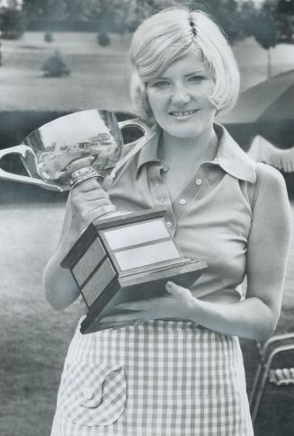 Mrs. Gayle Borthwick of Credit Valley holds trophy for winning T and D women's golf title at Weston Golf Club yesterday. Her fourth stright win is a record