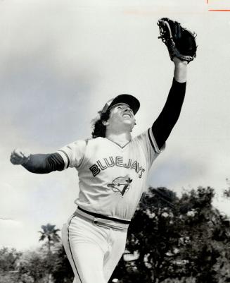 Rick Bosetti shields his eyes as he prepares to catch a fly ball