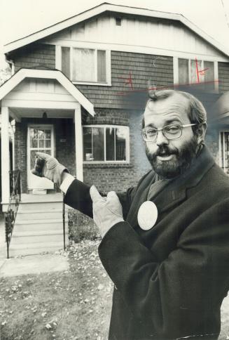 Image shows a politician John Bosley standing outside a residential house. 