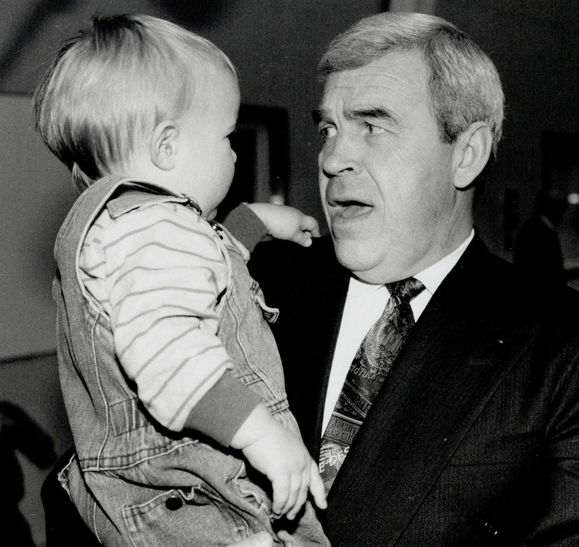 Uh oh: Health minister Benoit Bouchard seems to have second thoughts as he holds 15-months-old Jack Naughton yesterday at the Metro YMCA auditorium