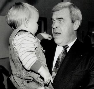 Uh oh: Health minister Benoit Bouchard seems to have second thoughts as he holds 15-months-old Jack Naughton yesterday at the Metro YMCA auditorium
