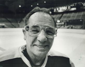 All the better to see you with, Leaf goalie coach Johnny Bower, sporting new pair of protective glasses he says help him see the puck better, suits up(...)