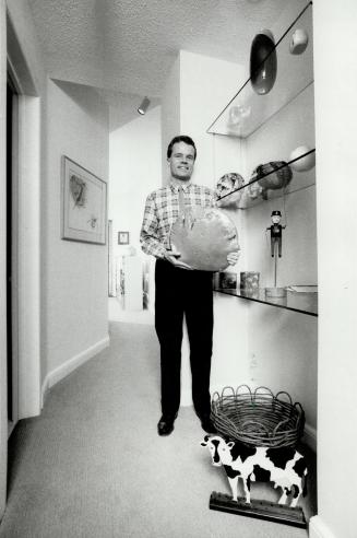Mini-gallery: Bill Boyle, director of the Art Gallery at Harbourfront, stands in the second-floor, art-filled hallway that connects the front and back sections of his Cabbagetown house