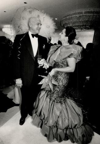 Above, lawyer Rudy Bratty chats with wife Cathie, in silk gown designed by John Artibello