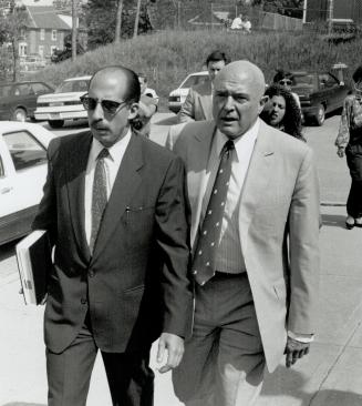 Grim: Lawyer Michael Cohen (left) leads developer Rudy Bratty, father of two of the accused, into court