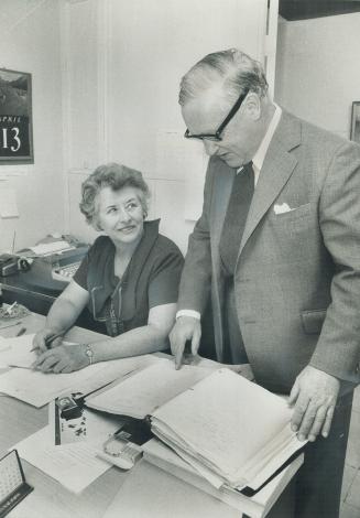 Toronto MP Andrew Brewin talks overa caller's problems with Eve Boal in the service office he operates on Main St