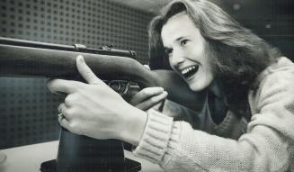 High jumper Debbie Brill tests marksmanship in hotel game room as she relaxes before Toronto Star Maple Leaf Games tonight