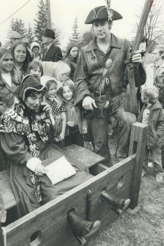 Mayor in the stocks. Margaret Britnell, King Township mayor, was put in stocks Saturday and guarded by rebel Bob Watts, member of the Upper Canada Rif(...)