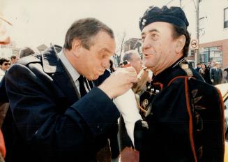 Greek water, eh? Federal NDP leader Ed Broadbent takes a sip from a goatskin offered by Chris Stanois of the Pan-Macedonian Association at the Green I(...)