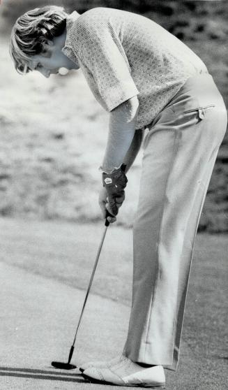 George Burns III, winner of Canadian Amateur championship, finds his mouth a convenient receptacle for golf ball as he tests his swing for his final putt