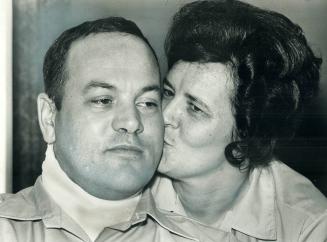 Hit by a shotgun blast from a passing car Saturday night, Constable Harry Burridge gets a kiss from his wife, Cookie