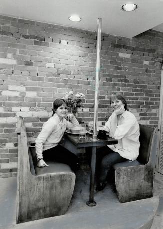 Bit of history: Sara Brooke and her mom have snack at restaurant table recycled from old Riverboat coffee house