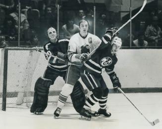 Gerry Cheevers, Cleveland Crusaders' goalie, has view partially blocked by Toros' Wayne Carleton who jostles with defenceman Tom Edur in second game o(...)