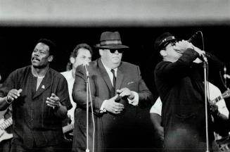 Big and bad: The Elwood Blues Review, from left, blues singer Larry Thurston, Argo co-owner John Candy and actor Dan Aykroyd, perform at the game