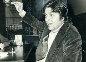 Quebec novelist Roch Carrier relaxes in a restaurant owned by a member of the Toronto Maple Leafs - not exactly a favorite symbol for any red-blooded (...)
