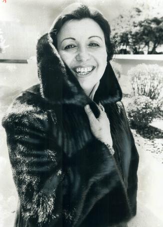 Clarice Carson, soprano singer, models $10,000 brown Russian broadtail coat with natural Russian sable collar
