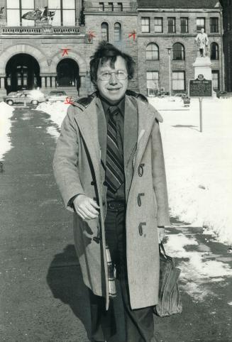 Michael Cassidy, carrying his 10-year-old battered briefcase, leaves the Legislature