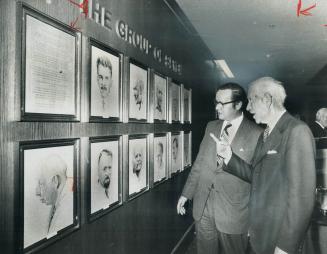 Group of seven artist A.J. Casson (right) points out the finer points of sketches of his colleagues to Arthur Meen. Ontario's minister of revenue, in (...)